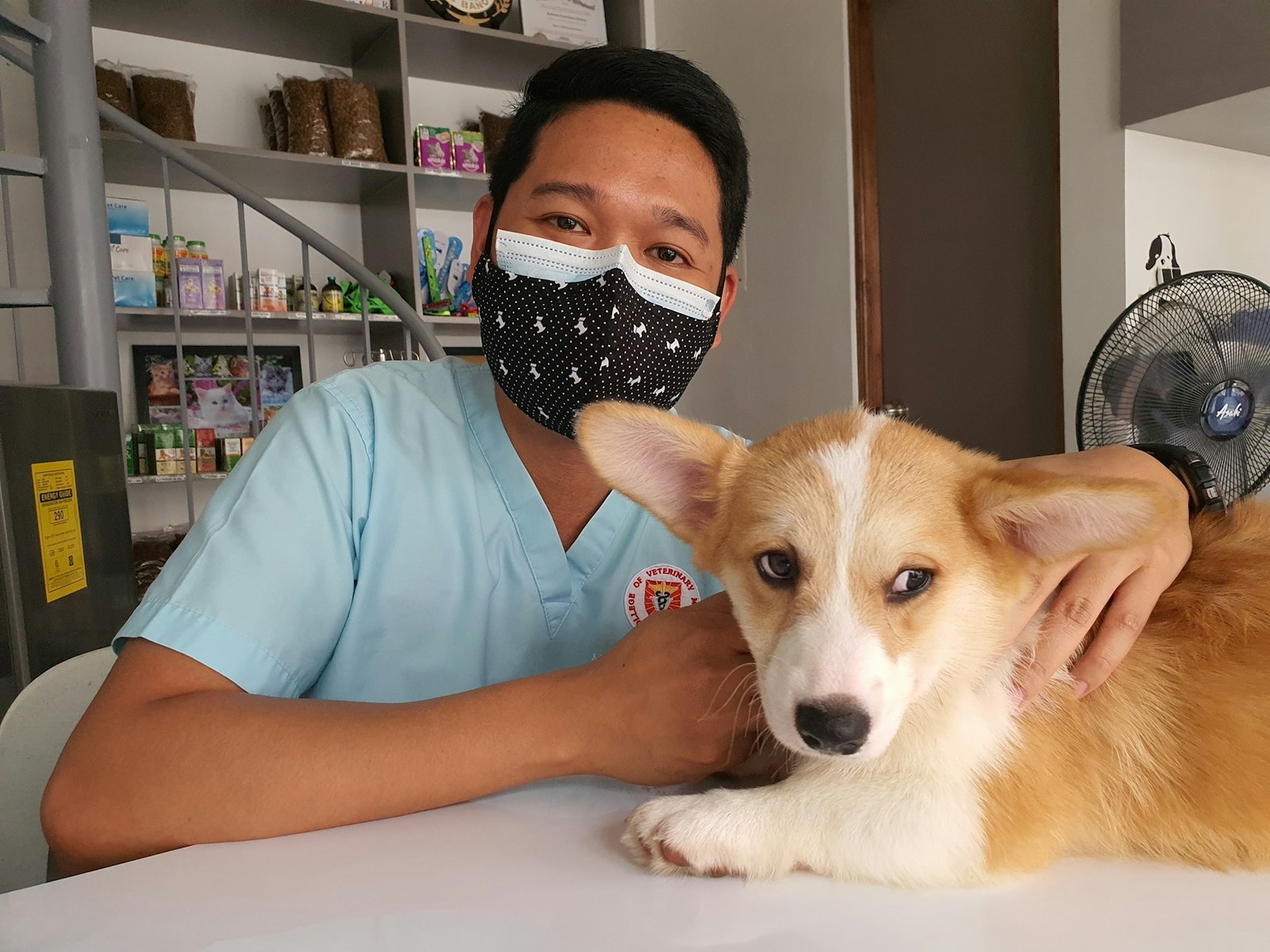 A masked man seated beside a dog